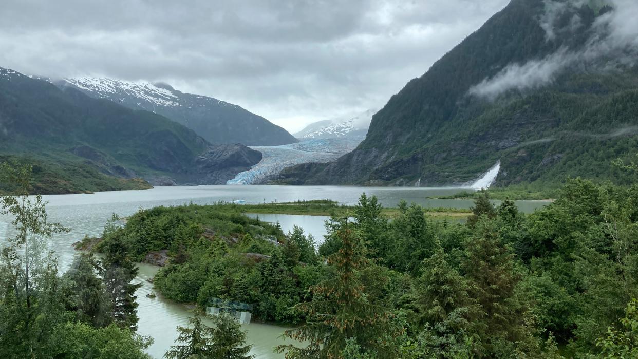 The Mendenhall Glacier, rear, is seen from the glacier visitor center, on June 30, 2023, in Juneau, Alaska. Nugget Falls is on the right.