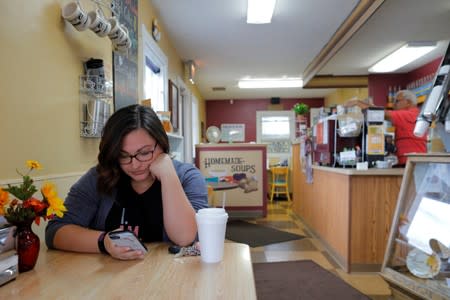 Carlee Giordano looks at her mobile phone at the Morning Emporium Coffee House in Saginaw Township