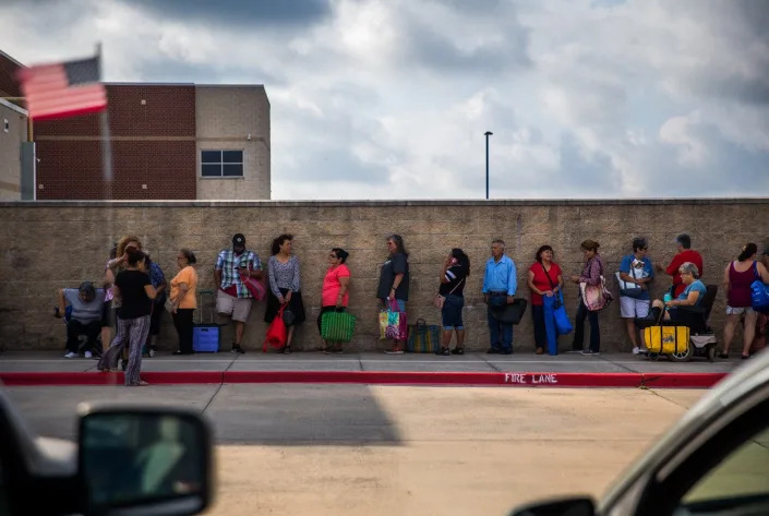 People in need wait to receive food from a mobile food pantry in Kyle. Texans who receive food stamps for their families must renew their status every six months.