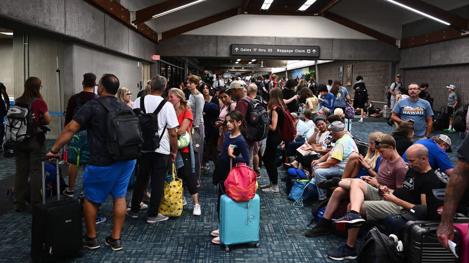 Passengers try to rest or sleep after canceled and delayed flights while others wait to board flights off the island as thousands of passengers were stranded at the Kahului Airport (OGG) in western Maui in Kahului, Hawaii, on August 9. - Patrick T. Fallon/AFP/Getty Images