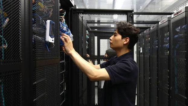 An employee checks a server room in the Samsung Networks' Telco Data Center