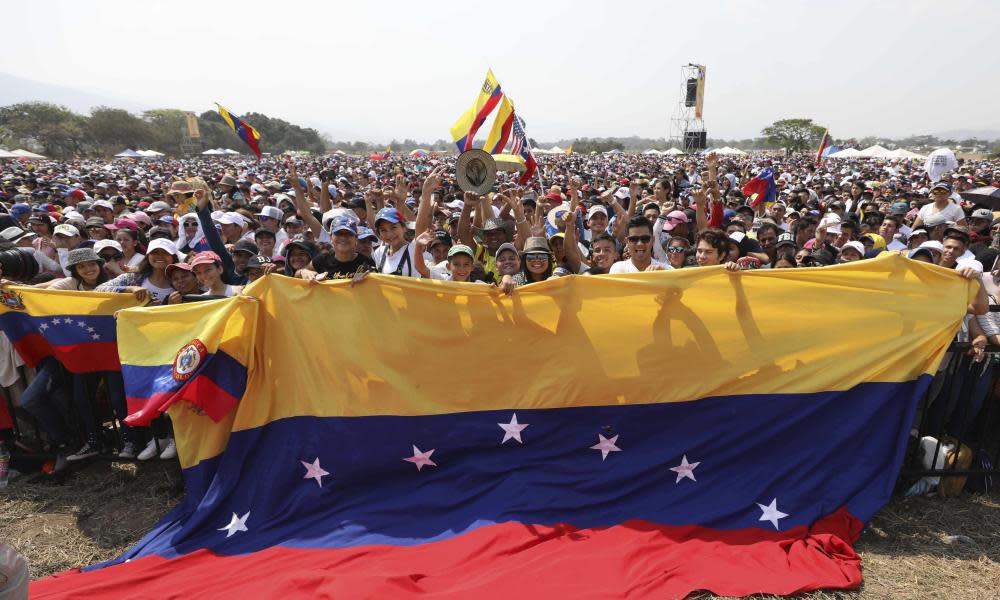 Concert goers unfurl a large Venezuelan flag during the Venezuela Aid Live concert