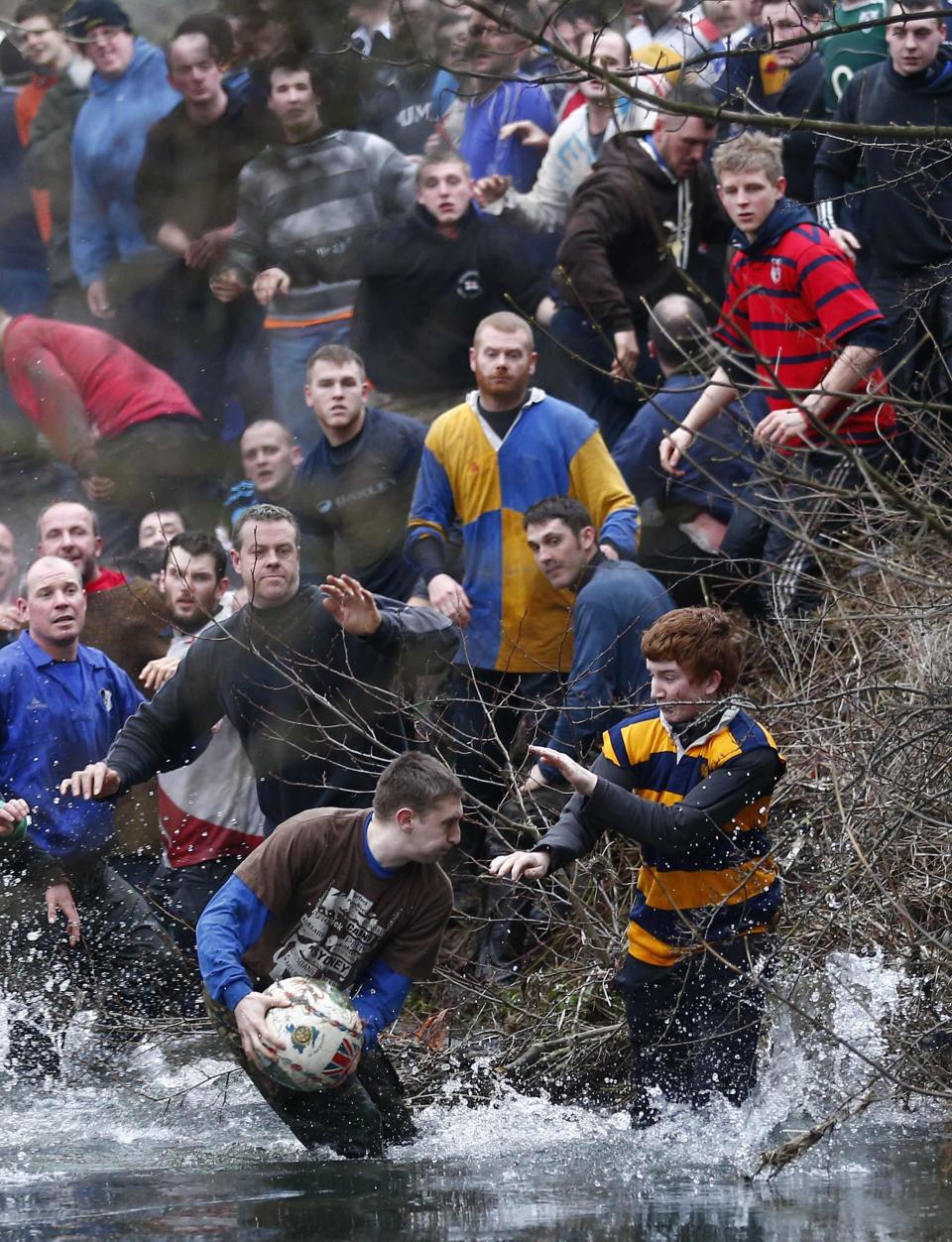 �The ball breaks from the hug in Ashbourne. The aim of the teams is to score by tapping the ball three times on stone goal plinths three miles apart on the banks of the River Henmore (Reuters)