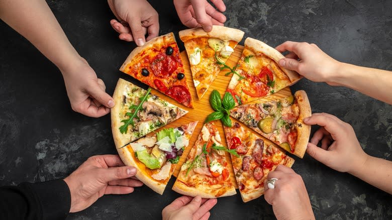 People grabbing multiple slices of pizza