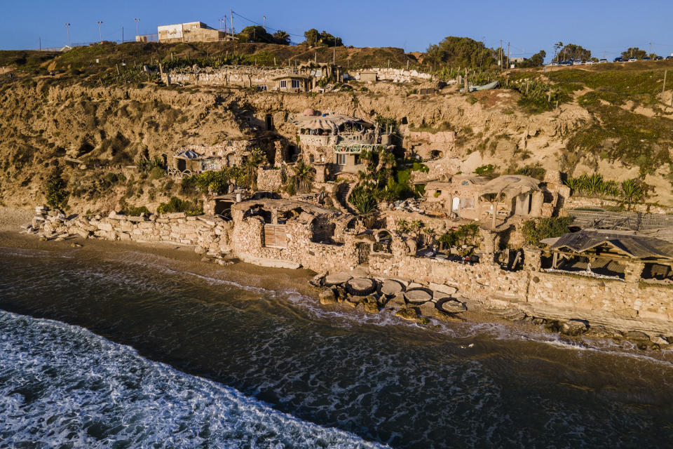 Nissim Kahlon's home, chiseled out of the sandstone cliffs, overlooks the Mediterranean sea in Herzliya, Israel, Wednesday, June 28, 2023. Over half a century, Kahlon has transformed a tiny cave on a Mediterranean beach into an elaborate underground labyrinth filled with chiseled tunnels, detailed mosaic floors and a network of staircases and mysterious chambers. Fifty years after Kahlon moved into the home, Israel's Environmental Protection Agency has served him an eviction notice, claiming the structure threatens Israel's coastline. (AP Photo/Ariel Schalit)