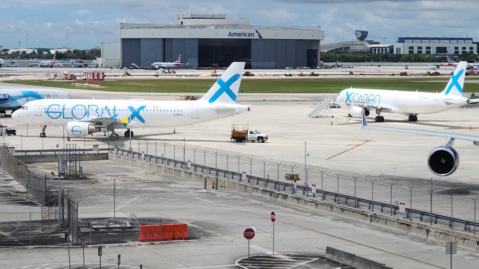 Global X cargo jets with light-blue lettering parked on an open tarmac.