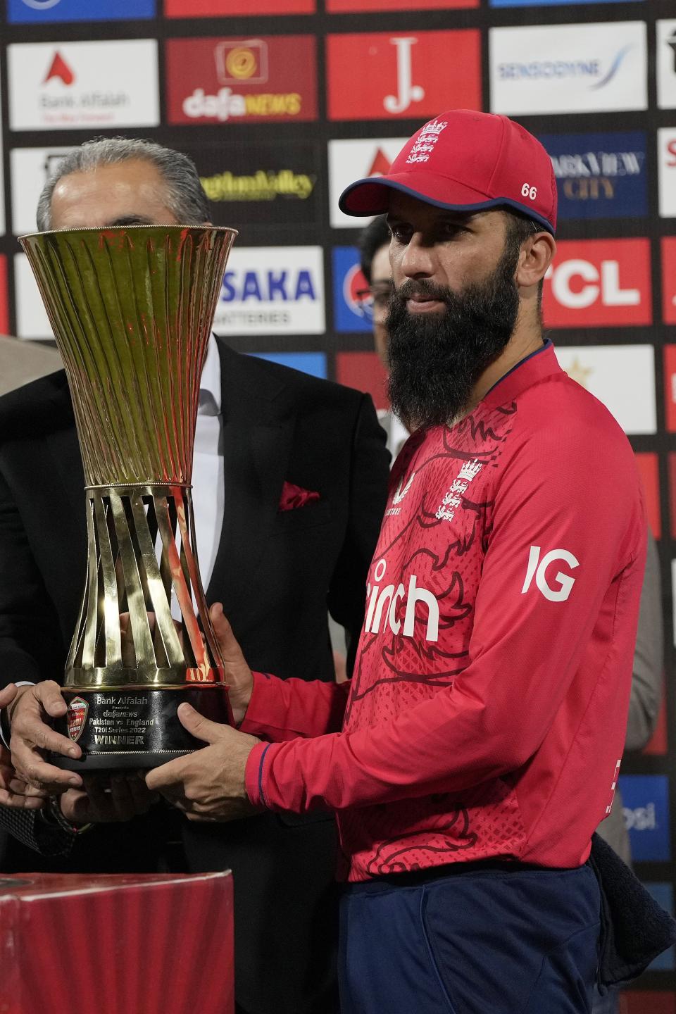 England's skipper Moeen Ali receives trophy after winning the twenty20 series during a presentation ceremony on the end of the seventh twenty20 cricket match between Pakistan and England, in Lahore, Pakistan, Sunday, Oct. 2, 2022. (AP Photo/K.M. Chaudary)