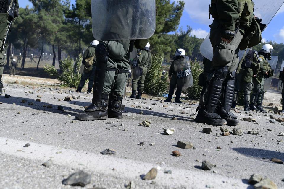 Riot police block a road during clashes in Karava near the area where the government plans to build a new migrant detention center, on the northeastern Aegean island of Lesbos, Greece, Wednesday, Feb. 26, 2020. Local authorities declared a 24-hour strike on two eastern Greek islands Wednesday to protest government plans to build new migrant detention camps there. (AP Photo/Michael Varaklas)