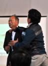 A relative (R) of a passenger onboard the capsized ferry hits a South Korean government official (L-name unavailable) during a briefing on the rescue situation at a gym in Jindo on April 17, 2014