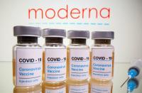 FILE PHOTO: Vials and medical syringe are seen in front of Moderna logo in this illustration