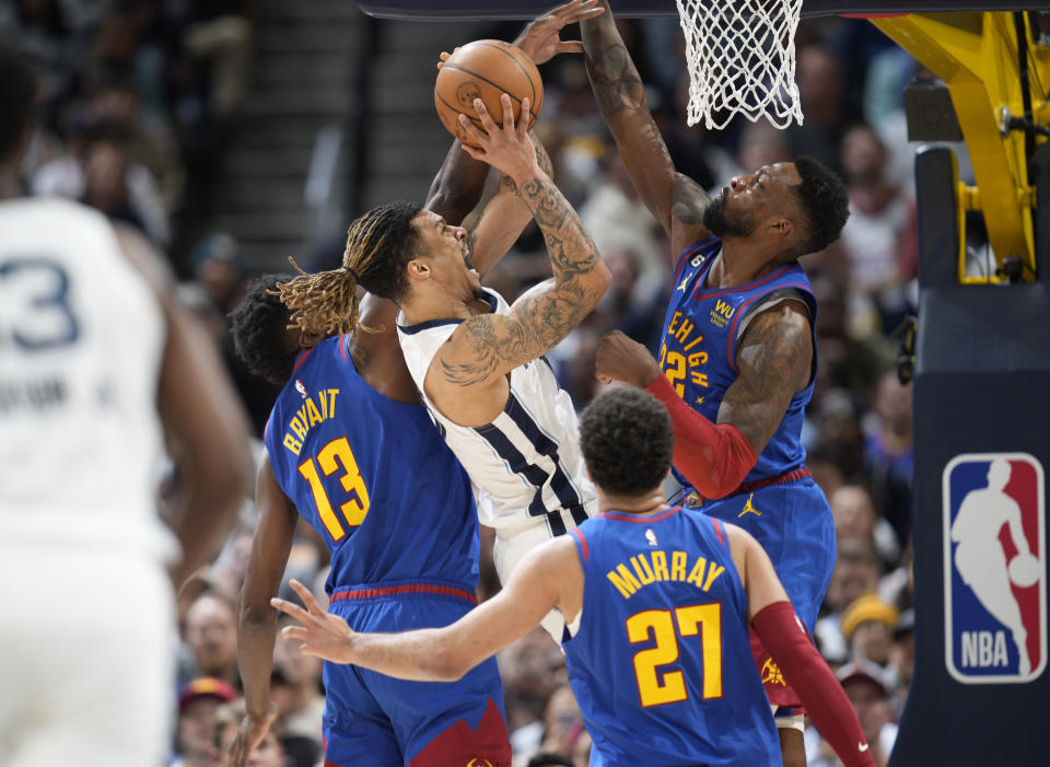 Memphis Grizzlies forward Brandon Clarke, top center, is fouled as he goes up for a basket as Denver Nuggets center Thomas Bryant, top left, and forward Jeff Green, top right, defend with Nuggets guard Jamal Murray (27) watching in the first half of an NBA basketball game Friday, March 3, 2023, in Denver. (AP Photo/David Zalubowski)