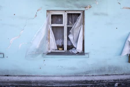 A window of a house which was damaged by fighting is seen in the town of Vuhlehirsk February 25, 2015. REUTERS/Baz Ratner