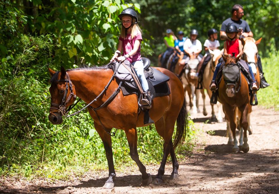 Ella Lowery, 8, of Louisiana, rides Nellie during an hour-and-a-half horseback ride with her friend and dad on June 17. Patrons were ziplining, horse back riding and panning for stones at the Canyons Zip Line and Adventures Park.