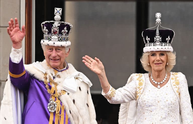 El rey Carlos III de Gran Bretaña y la reina Camilla saludan desde el balcón del Palacio de Buckingham tras ver el sobrevuelo de la Royal Air Force en el centro de Londres el 6 de mayo de 2023, después de sus coronaciones.