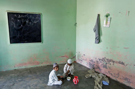 FILE PHOTO: Muslim children eat their lunch during a break at a madrasa or religious school in village Nayabans in the northern state of Uttar Pradesh, India May 9, 2019. REUTERS/Adnan Abidi