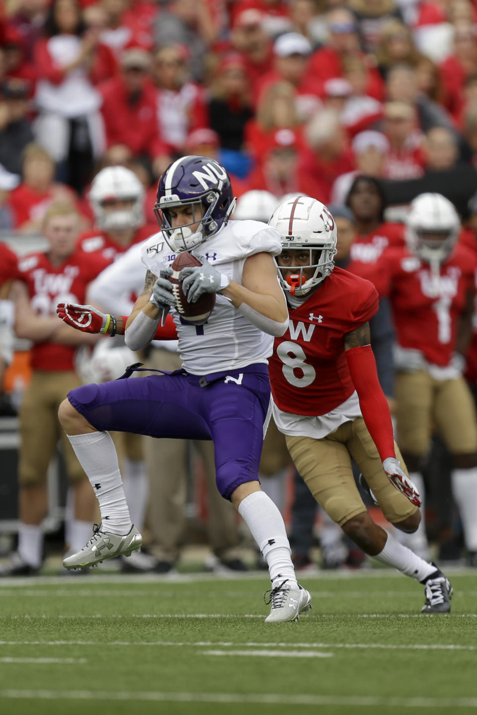 Northwestern wide receiver Berkeley Holman (4) makes a reception against Wisconsin cornerback Deron Harrell (8) during the first half of an NCAA college football game Saturday, Sept. 28, 2019, in Madison, Wis. (AP Photo/Andy Manis)