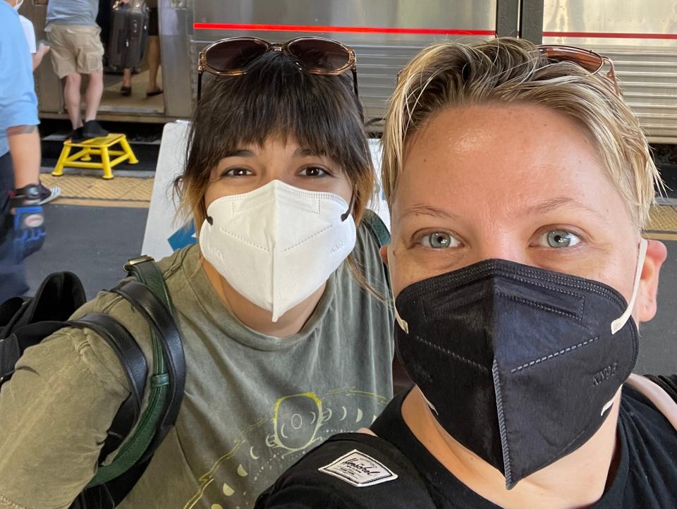 Anya Crittenton and her wife wearing masks in front of an Amtrak