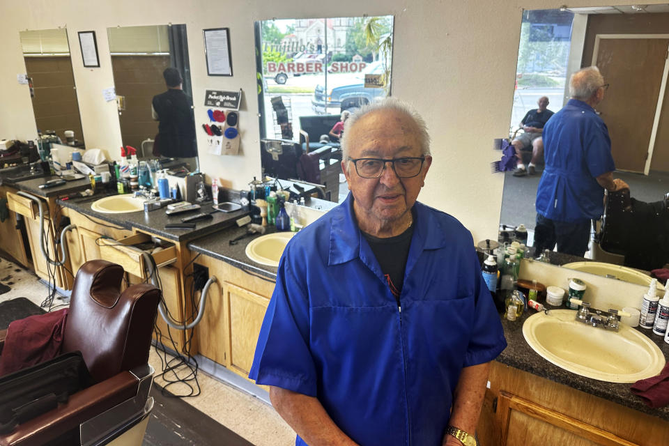 Eli Trujillo poses inside his barbershop in Cheyenne, Wyo., Thursday, July 18, 2024. Trujillo, 87, says he doesn’t work as many hours or cut hair as fast as he once did but isn’t one to judge whether President Joe Biden should continue to seek re-election. (AP Photo/Mead Gruver)