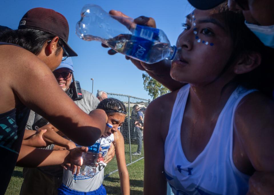 Hopi High School team members Edith Silas (right) and Shelton Tuvasi (center) receive assistance after finishing the Division 4 Girls AIA State Cross Country State Championship race on Nov. 13, 2021, at the Cave Creek Golf Course in Phoenix.