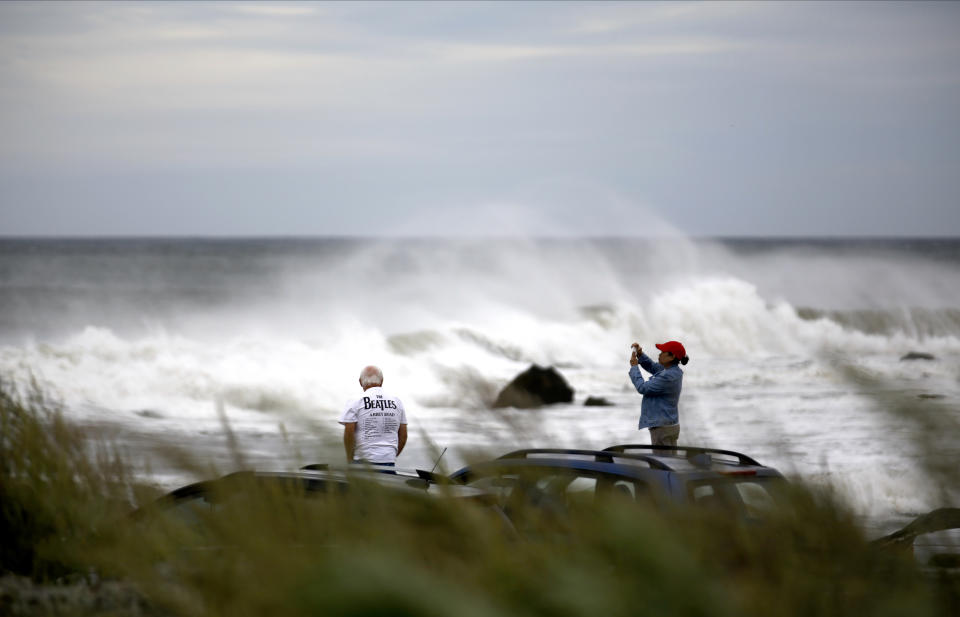 People watch waves from Lee, Saturday, Sept. 16, 2023, in Rye, N.H. The storm is expected to make landfall Saturday in Canada at near hurricane strength and then move farther into the region. (AP Photo/Caleb Jones)