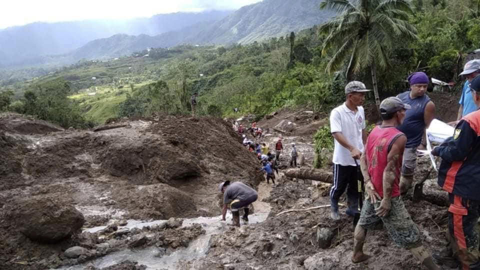 In this image provided by the Department of Public Works and Highways, Mountain Province District Engineering Office, rescuers dig through the earth to search for survivors after a massive landslide in Natonin township, Mountain Province in northern Philippines Wednesday, Oct. 31, 2018. A massive landslide set off by a typhoon crashed down on two government buildings in a northern Philippine mountain province, officials said Wednesday. (DPWH MPDSEO via AP)