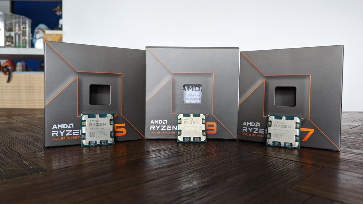 A picture of the AMD Ryzen 7900x, 7700x, and 7600x with their original packaging on a wooden table.