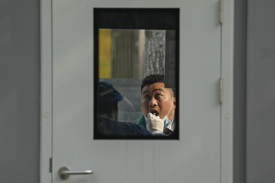 A man gets his routine COVID-19 throat swab at a coronavirus testing site in Beijing, Wednesday, Nov. 2, 2022. (AP Photo/Andy Wong)