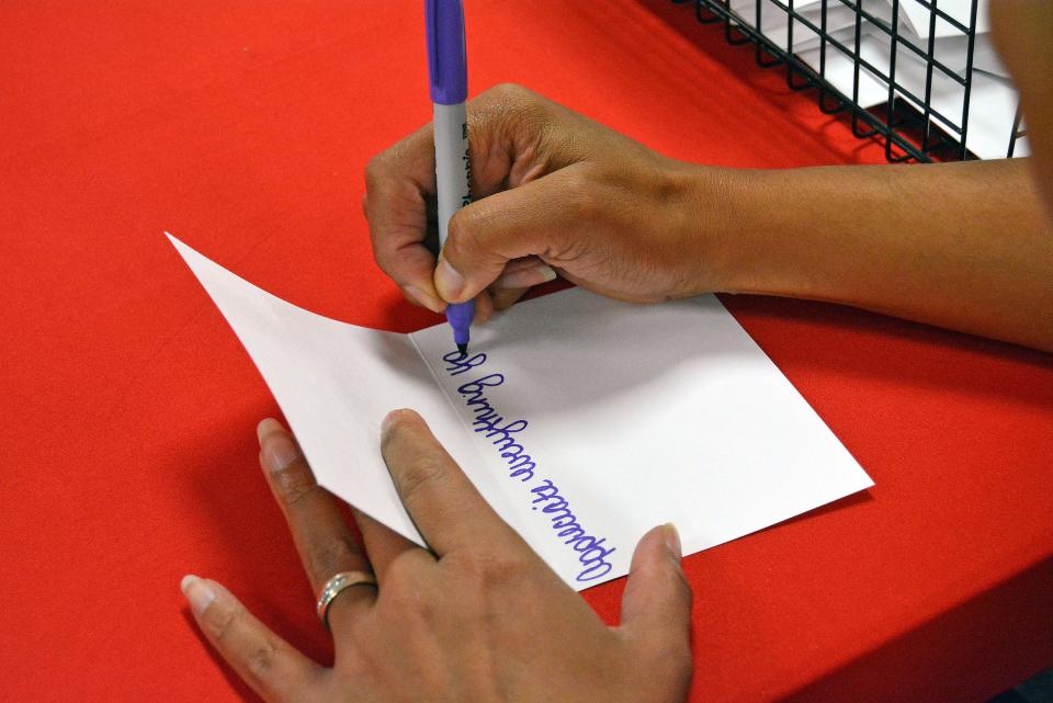 Veterans United Home Loans employee Shannon Alvis writes a note of appreciation that will go in a care kit from Operation Gratitude for currently deployed troops. Kits were prepared Thursday at Columbia American Legion Post 202.
