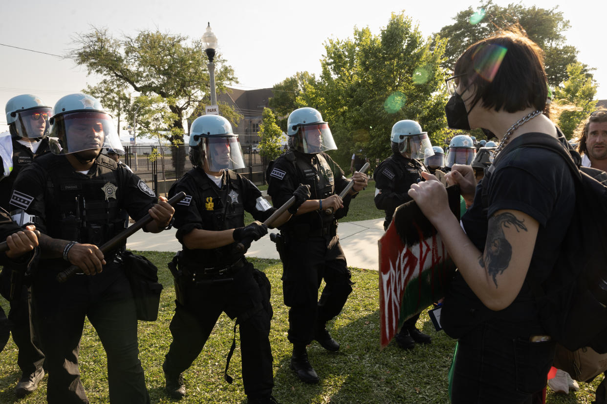 Helmeted police attempt to clear a park of demonstrators near the United Center in Chicago on Monday. 