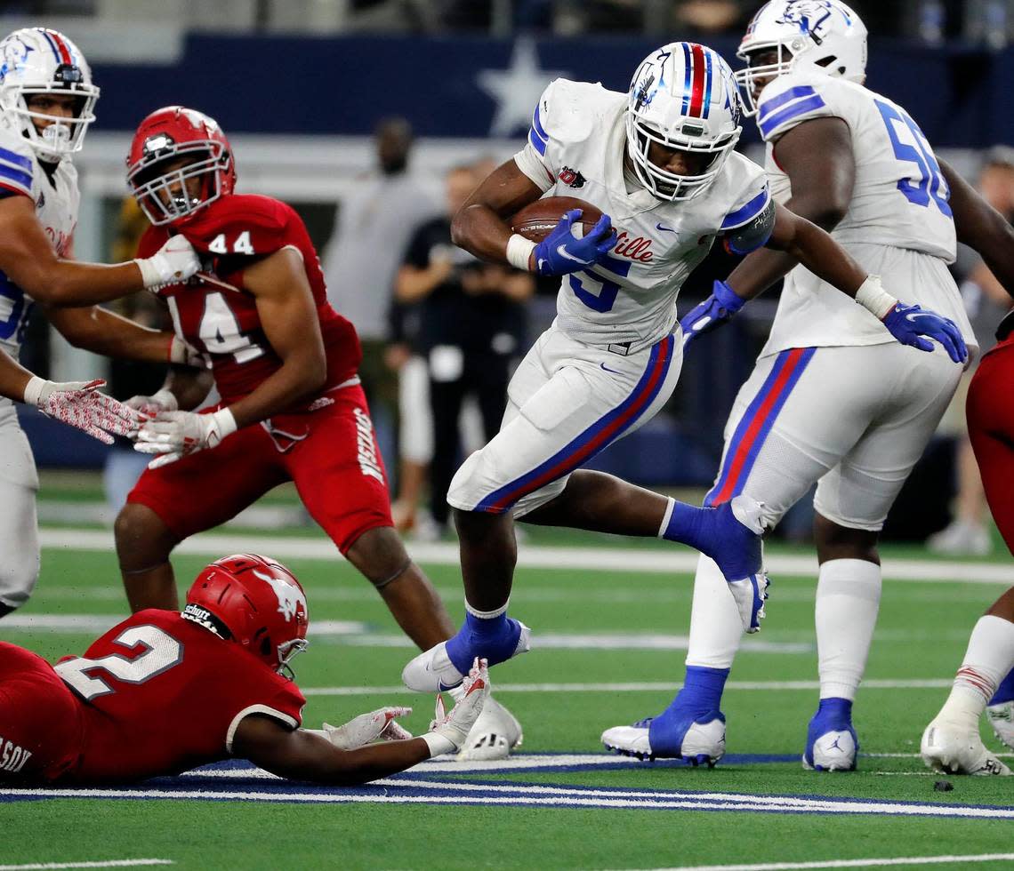 Duncanville running back Malachi Medlock (5) avoids a shoestring tackle by North Shore defensive back Caleb Flagg (2) during a high school 6A division 1 state championship football game at AT&T Stadium in Arlington, Texas, Saturday, Dec. 18, 2021. North Shore defeated Duncanville 17-10. (Special to the Star-Telegram Bob Booth) Bob Booth/Bob Booth