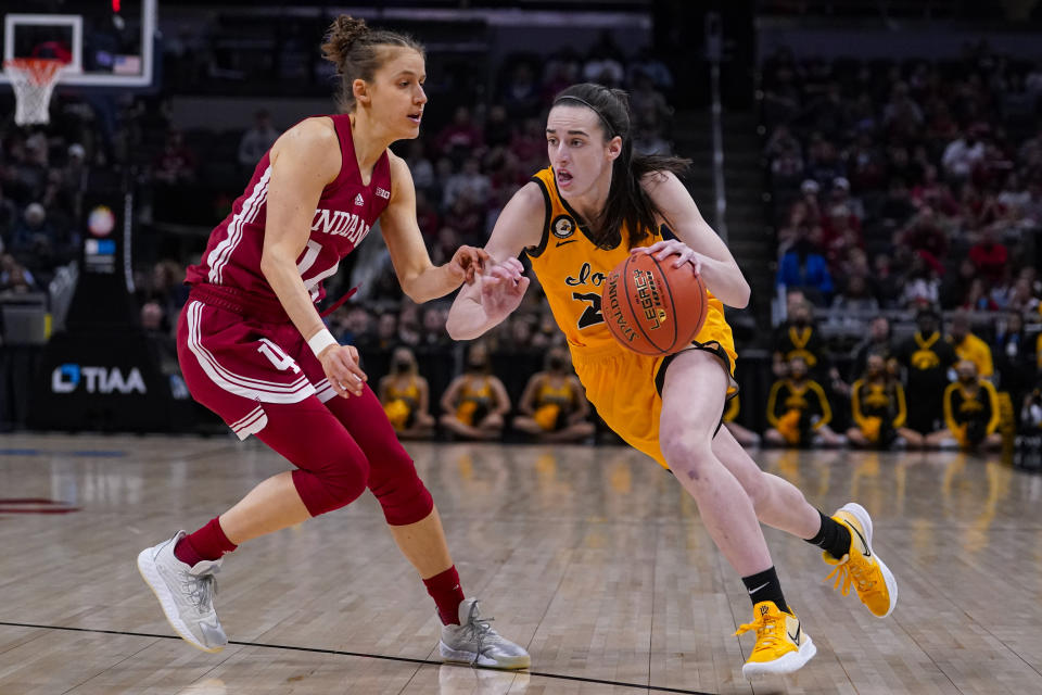 Iowa guard Caitlin Clark (22) drives on Indiana guard Ali Patberg (14) in the first half of an NCAA college basketball game for the championship of the Big Ten Conference tournament in Indianapolis, Sunday, March 6, 2022. (AP Photo/Michael Conroy)