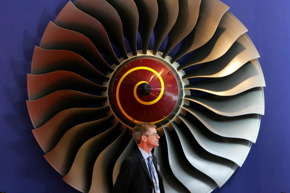 An exhibitor stands in front of a booth displaying Rolls-Royce aircraft engines on the first day of the 6th China International Aviation & Aerospace Exhibition in Zhuhai in China's southern Guangdong province, October 31, 2006.   REUTERS/Bobby Yip  (CHINA)