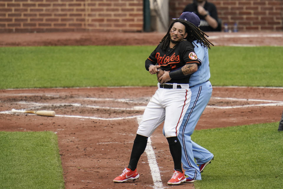 Baltimore Orioles' Freddy Galvis, left, is restrained by Toronto Blue Jays first base Vladimir Guerrero Jr. during a benches-clearing argument in the fourth inning of a baseball game, Saturday, June 19, 2021, in Baltimore. The incident happened as a result of Blue Jays' starting pitcher Alek Manoah hitting Orioles' Maikel Franco with a pitch after Manoah gave up back-to-back home runs to Ryan Mountcastle and DJ Stewart. (AP Photo/Julio Cortez)