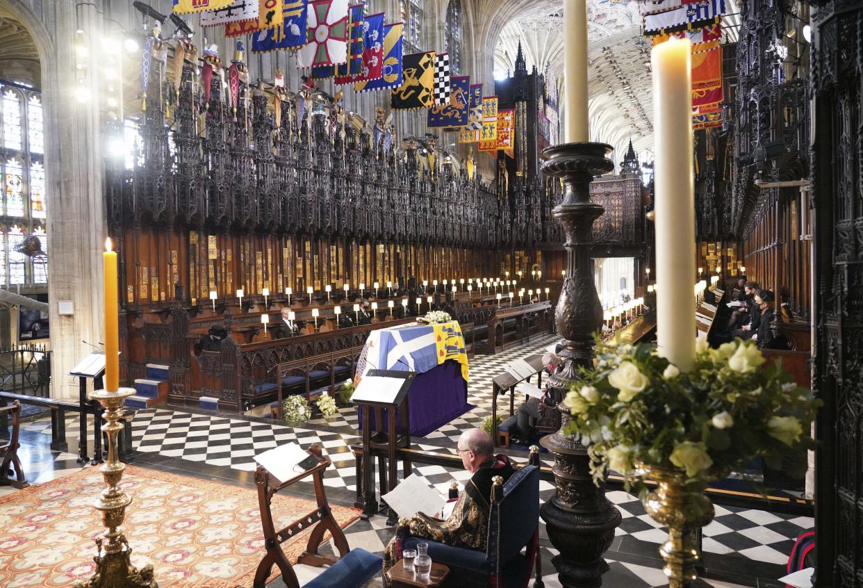 Britain's Queen Elizabeth II, left, and other guests look on the flag draped coffin in St. George’s Chapel during the funeral of Prince Philip, at Windsor Castle, Windsor, England, Saturday April 17, 2021.