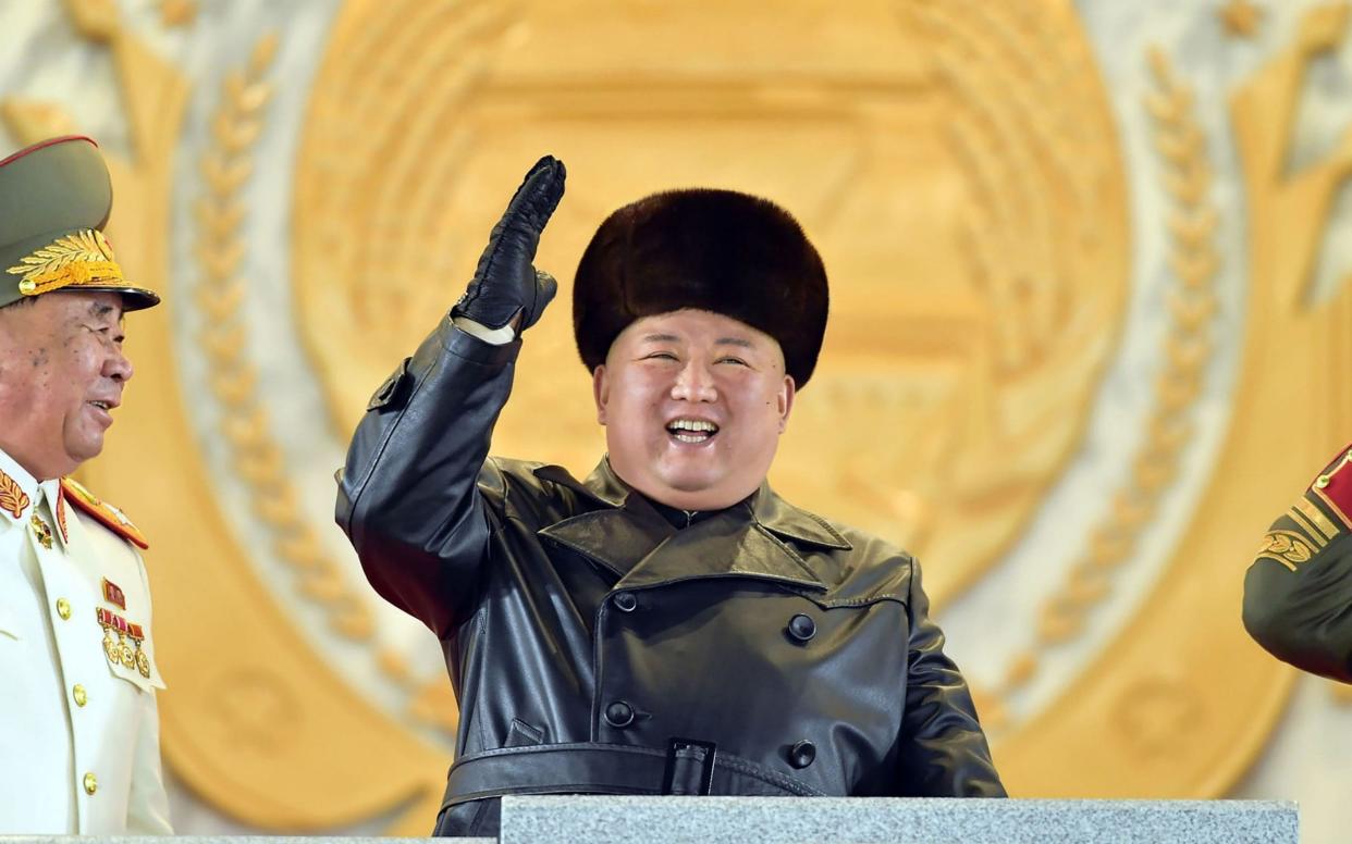 Kim Jong-un looked joyful as he presided over a parade of new weapons - AFP