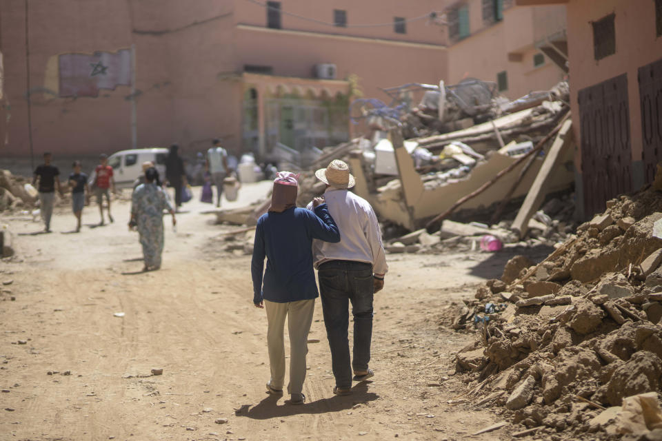 People walk through the wreckage caused by the earthquake, in the town of Amizmiz, near Marrakech, Morocco, Sunday, Sept. 10, 2023. An aftershock rattled Moroccans on Sunday as they mourned victims of the nation’s strongest earthquake in more than a century and sought to rescue survivors while soldiers and aid workers raced to reach ruined mountain villages. (AP Photo/Mosa'ab Elshamy)