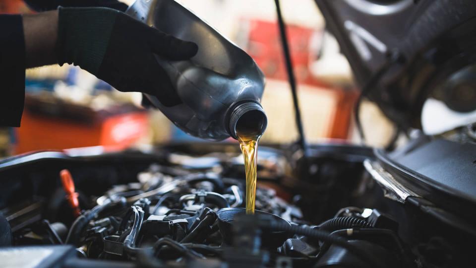 Close up hands of unrecognizable mechanic doing car service and maintenance.