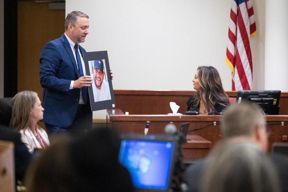 Sabrina Hull looks at a photo of her late husband Garrett Hull, a 17-year Fort Worth police veteran, who was fatally shot in 2018, on the first day of Timothy Huff’s murder trial on Monday, June 6, 2022, in Tarrant County’s 396th District Court.