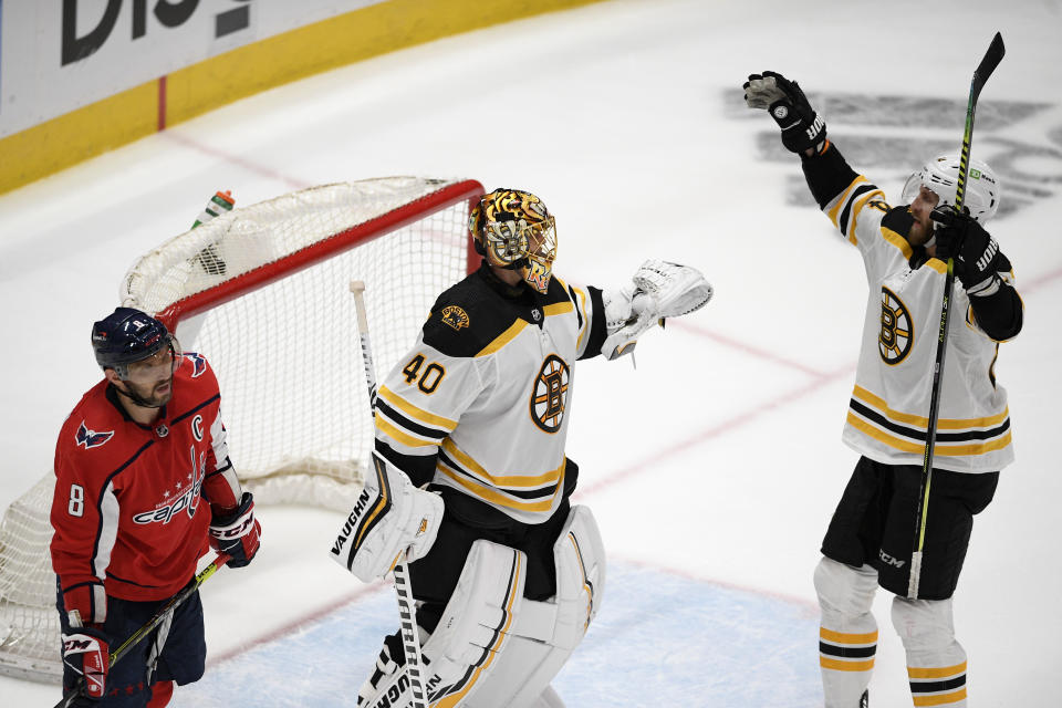 Boston Bruins goaltender Tuukka Rask (40) and defenseman Jarred Tinordi, right, celebrate after Game 5 of an NHL hockey Stanley Cup first-round playoff series as Washington Capitals left wing Alex Ovechkin (8) skates away, Sunday, May 23, 2021, in Washington. The Bruins won 3-1. (AP Photo/Nick Wass)
