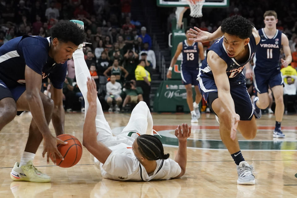 Miami guard Isaiah Wong (2) looses control of the ball as Virginia guard Reece Beekman (2) grabs it during the second half of an NCAA college basketball game, Tuesday, Dec. 20, 2022, in Coral Gables, Fla. (AP Photo/Marta Lavandier)
