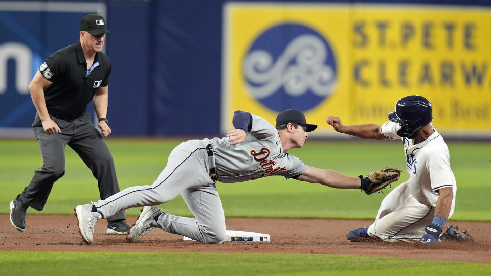 Detroit Tigers second baseman Colt Keith, center, tags out Tampa Bay Rays' Amed Rosario, right, attempting to steal second base during the first inning of a baseball game Monday, April 22, 2024, in St. Petersburg, Fla. Making the call is umpire Ryan Blakney. (AP Photo/Chris O'Meara)