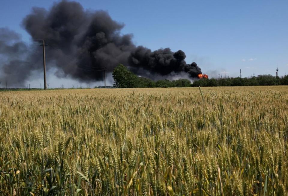 A fire burns behind a field of wheat after shelling in Andriivka, the Kharkiv region, in June.