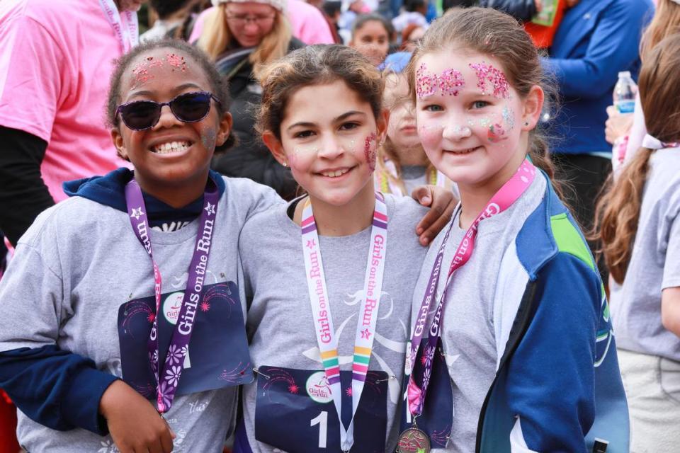 Three young participants in a “Girls on the Run” 5-kilometer run in Charlotte in December 2022 pose for a photo.