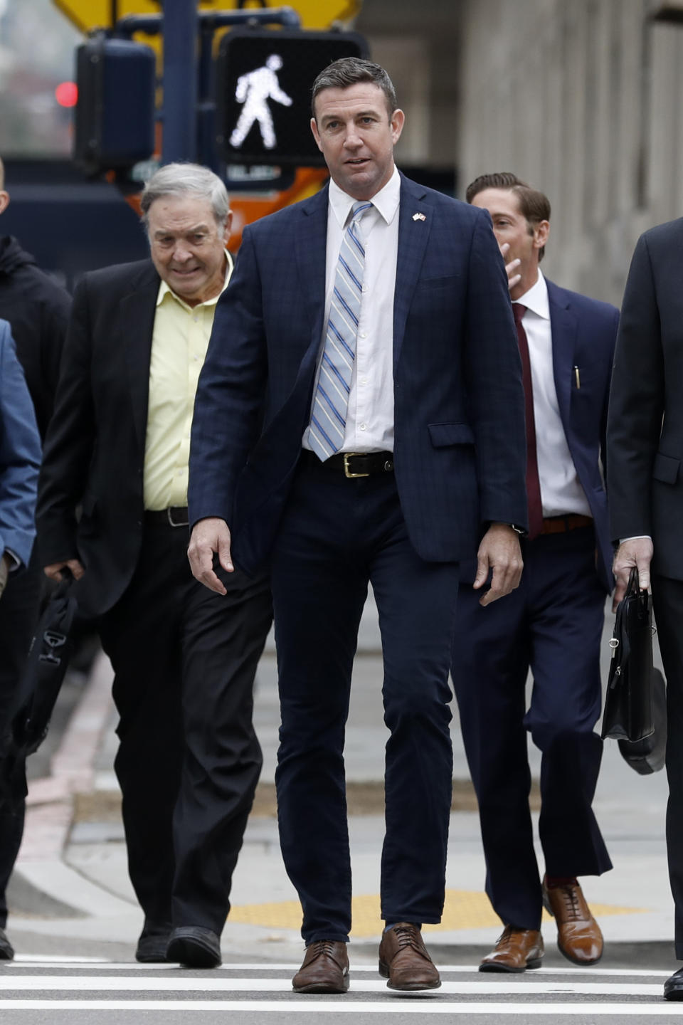 California Republican Rep. Duncan Hunter, center, walks towards federal court in front of his father, former Rep. Duncan L. Hunter, left, Tuesday, Dec. 3, 2019, in San Diego. Hunter said in a TV interview that aired Monday he plans to plead guilty to the misuse of campaign funds at a federal court hearing Tuesday in San Diego. (AP Photo/Gregory Bull)