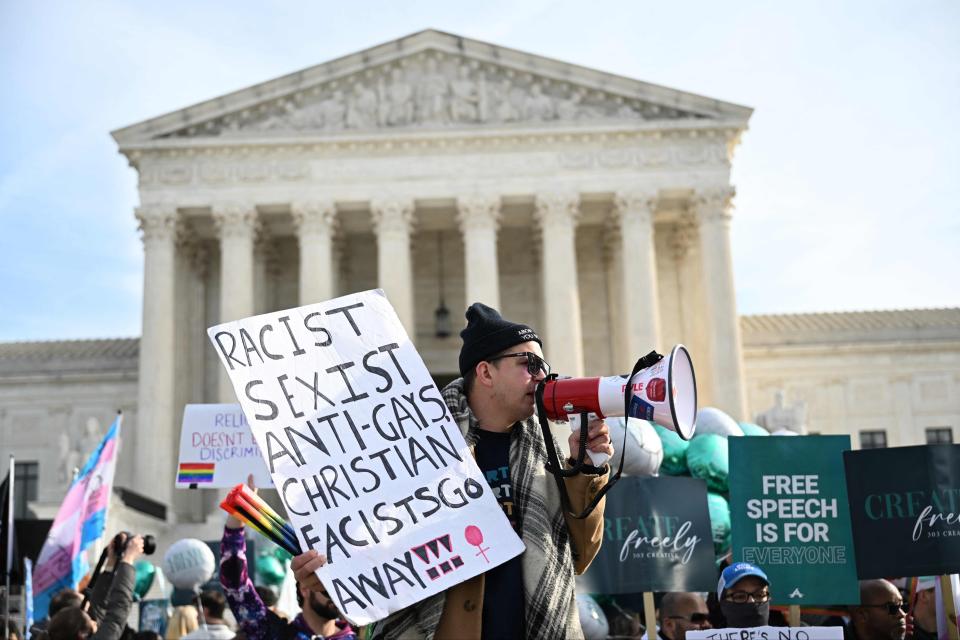 A few dozen people demonstrate in front of the Supreme Court on Monday during the oral arguments in a case involving a suit filed by Lorie Smith, owner of 303 Creative, a website design company in Colorado arguing that as a devout Christian she cannot produce wedding websites for same-sex weddings because it would be "inconsistent" with her religious beliefs.