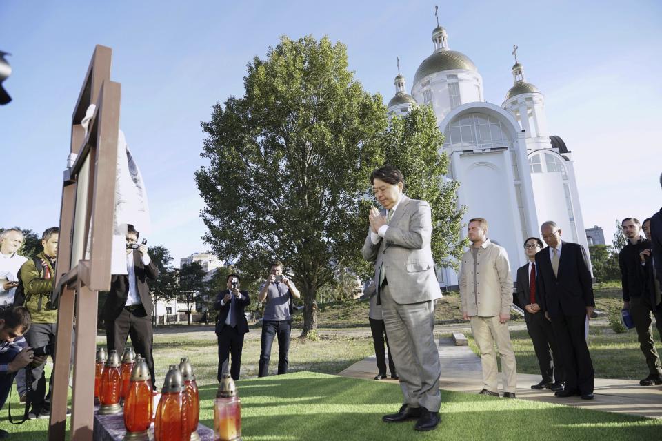 Japanese Foreign Minister Yoshimasa Hayashi, center, offers prayers at a church during his visit to Bucha, one of the hardest-hit towns on the outskirts of Kyiv, Ukraine, Saturday, Sept. 9, 2023. Foreign Minister Hayashi, accompanied by a number of business leaders, is visiting Ukraine on Saturday for talks with his counterpart to show support for the war-torn country and emphasize his country's backing of sanctions against Russia, the Japanese foreign ministry said in a statement.(Kyodo News via AP)