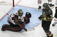 Vegas Golden Knights' William Karlsson (71)watches as Chicago Blackhawks goalie Corey Crawford (50) makes a save during the third period of an NHL hockey Stanley Cup first-round playoff series, Thursday, Aug. 13, 2020, in Edmonton, Alberta. (Jason Franson/The Canadian Press via AP)