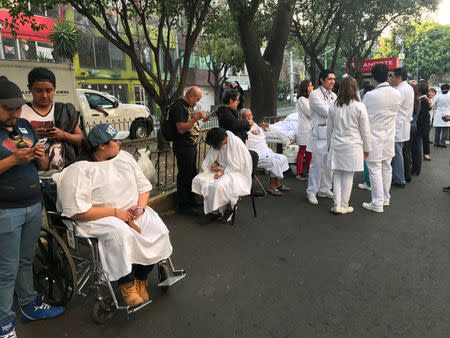 People stand on the street after an earthquake shook buildings in Mexico City, Mexico February 16, 2018. REUTERS/Claudia Daut