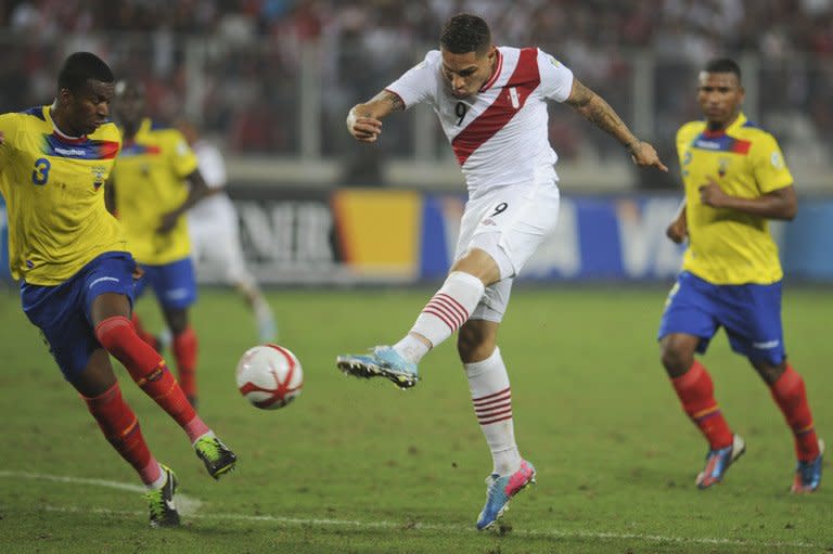 Ecuador's Frickson Erazo tries to block a shot from Peru's Paolo Guerrreo (R) during their Brazil 2014 World Cup South American qualifier match at the National Stadium in Lima on June 7, 2013. Peru won 1-0