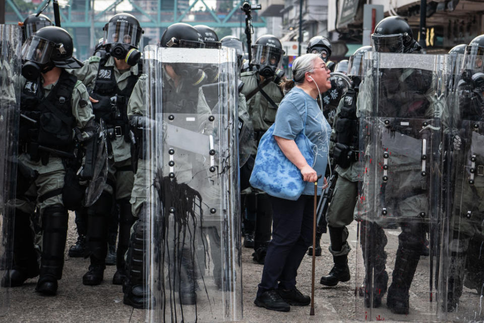 Eine ältere Frau schreit Polizisten in Hong Kong an, die gegen Demonstranten vorgehen. Im Sommer 2019 brachen in der chinesischen Sonderverwaltungszone Hongkong Massenproteste gegen die Peking-nahe Administration unter Carrie Lam aus. Anlass war ein vorgeschlagenes Gesetz über flüchtige Straftäter und Rechtshilfe in Strafsachen, welches u. a. Auslieferungen von Häftlingen an die Volksrepublik China ermöglichen sollte. (Bild: Getty Images)